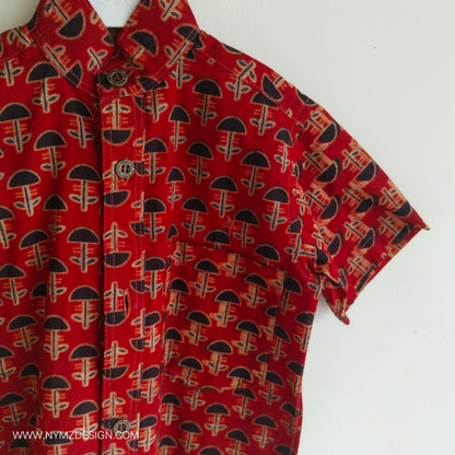 Close-up of star hand embroidery near pocket on Ajrakh brick red cotton kids shirt – handcrafted Indian handblock print design.metal buttons